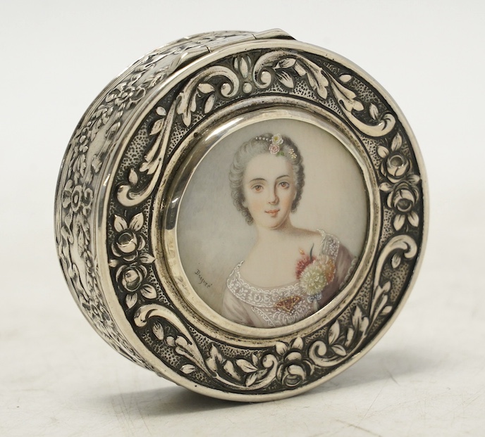 An early 20th century continental white metal circular snuff box, the cover with inset miniature watercolour of a lady signed Drepize?, 58mm. Condition - fair to good